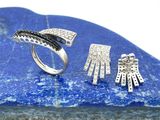 deux bijoux en argent posés sur une pierre bleue