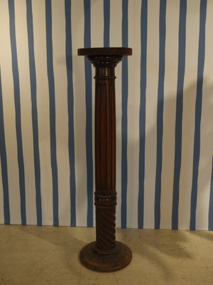 un grand mât en bois surmonté d'une horloge