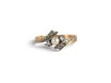 a close up of a gold ring with a pearl and diamonds