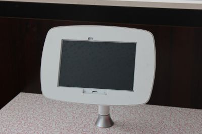 une petite tablette blanche posée sur un support, sur une table
