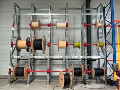 de nombreuses bobines et rouleaux rangés sur un rayonnage dans un entrepôt