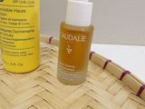 a bottle of oil and a bottle of lotion sitting on a basket
