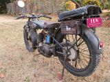 a old motorcycle that is parked in the grass