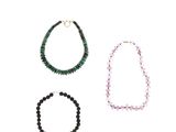 trois colliers de couleurs et de formes différentes sur un fond blanc