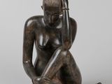 statue d'une femme assise par terre, la main posée sur la tête