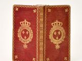 a red book with gold trim and a crown on top of it