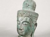 un gros plan sur une statue représentant une tête coiffée d'une couronne