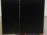 two speakers sitting on a wooden stand in a room