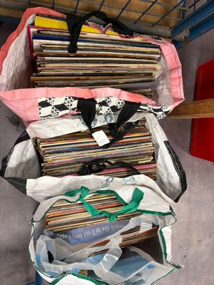 une pile de disques vinyles dans un sac posé par terre