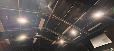 une grande salle avec beaucoup de lumières et un écran de projection