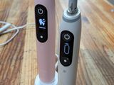 deux brosses à dents électriques posées sur une table en bois