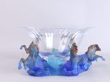 a glass vase with two horses in it on a table