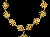 une image représentant un collier en or avec un pendentif en forme de croix