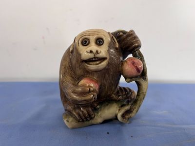 une figurine représentant un singe assis sur une branche d'arbre