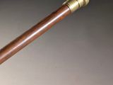 a close up of a pipe with a wooden handle on a table