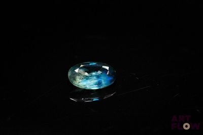 a close up of a blue crystal on a black surface