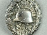 an image of a silver badge with a helmet on top of a wreath