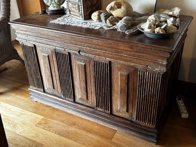 un coffre en bois orné d'une horloge et de quelques crânes