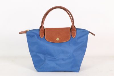 un sac à main bleu et marron posé sur une surface blanche