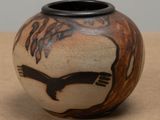 a vase with a bird on it sitting on a table