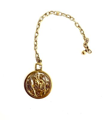 un gros plan d'un collier en or avec une pièce suspendue à une chaîne