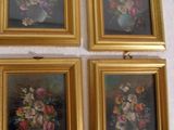 quatre tableaux encadrés représentant des fleurs dans un vase accrochés au mur