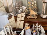 de nombreuses maquettes de bateaux posées sur une table dans une pièce