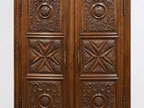 an antique wooden armoire with carved panels and drawers