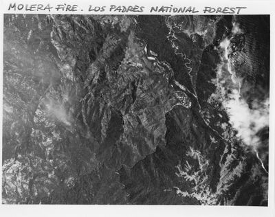 photographie en noir et blanc d'une chaîne de montagnes traversée par une rivière