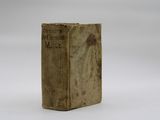 an old book sitting on top of a table on a white surface