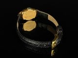 a close up of a gold watch on a black surface