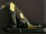a statue of a cat sitting on top of a black base