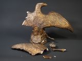 a sculpture of a bird that is sitting on the ground