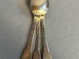 three spoons that are sitting on a table