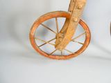 un petit vélo en bois posé sur une surface blanche