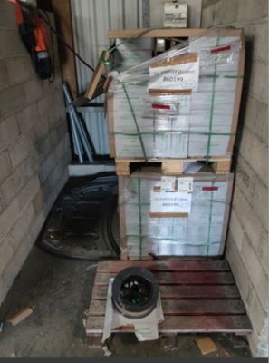 une pile de cartons posée sur une palette dans un garage
