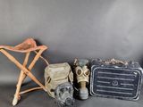 trois valises et un masque à gaz sont posés les uns à côté des autres