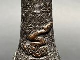 an image of a silver vase with a snake on the top of it
