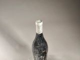 a bottle of wine sitting on top of a glass plate