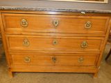 a wooden dresser with a marble top on a carpeted floor
