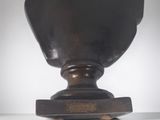 a black vase on a table with a white background