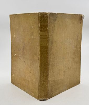 un vieux livre posé sur une table à côté d'un fond blanc