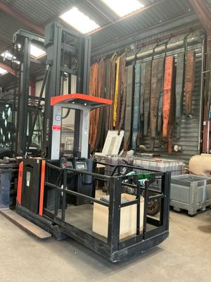 a fork lift truck in a warehouse with lots of items