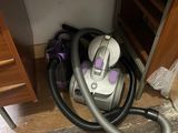 un aspirateur posé par terre à côté d'un bureau