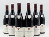 six bouteilles de vin sont alignées sur une surface blanche