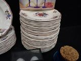 a stack of plates and a box of cookies on a table