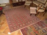 des tapis et des fauteuils dans un salon où se trouve un téléviseur posé sur un meuble TV