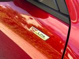 a close up of a red car with a chrome plate on it