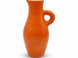 an orange vase with a curved handle on a white background