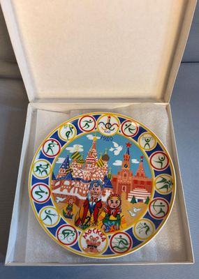 an open box with a decorative plate inside of it on a table